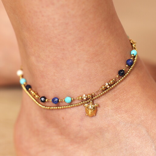 close-up of turtle pendant on model's ankle