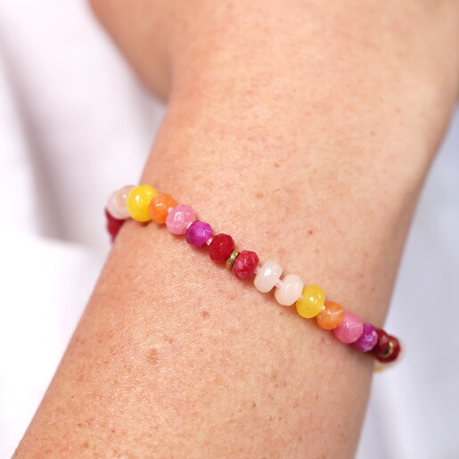 A Pink Red Purple Yellow and Orange Beaded Bracelet with Gold Spacers Close Up On Model