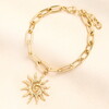 gold celestial bracelet against pale pink background