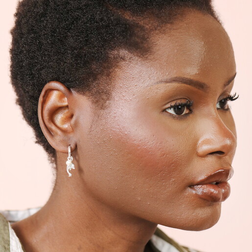 dolphin hoop earrings in silver against pale pink background