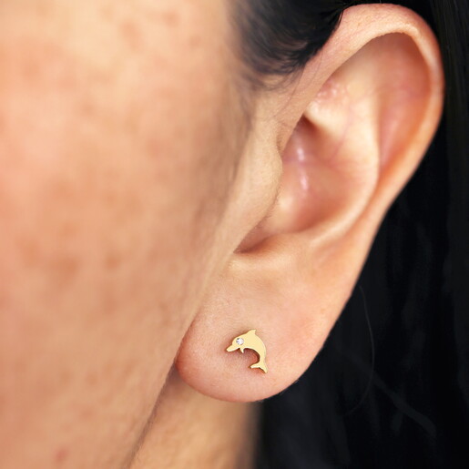 dolphin stud earrings with cubic zirconia detailing close up on model