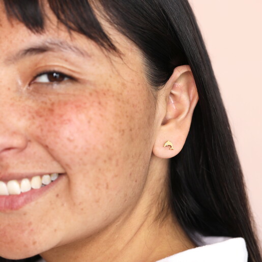 dolphin stud earrings with cubic zirconia detailing on model
