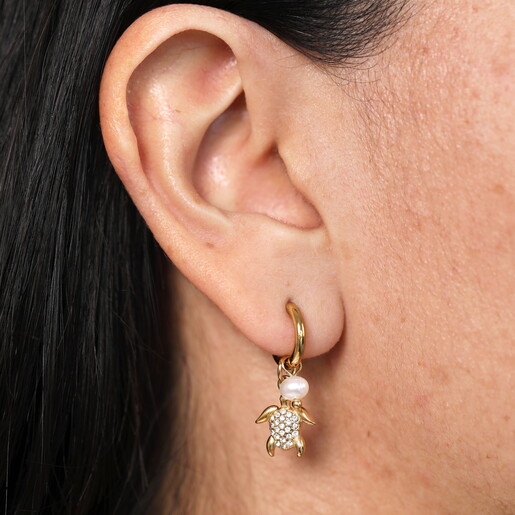 seaside huggie hoop earrings in gold close up on model