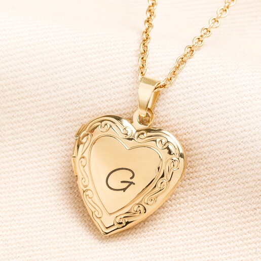 A Gold Heart Shaped Pendant Necklace With a G Initial Engraved on the Front