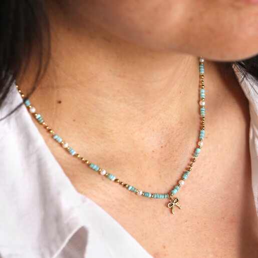 green and gold stainless steel bow charm necklace close up on model