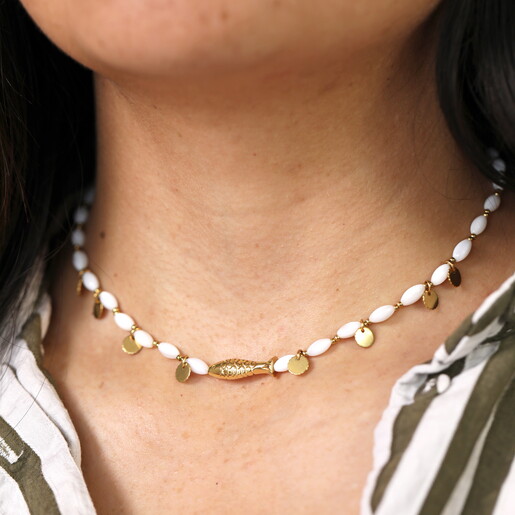 white beaded necklace with fish charm in gold close up on model fish charm in gold