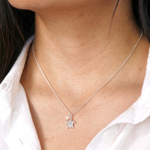 tiny turtle pendant necklace in silver close up on model