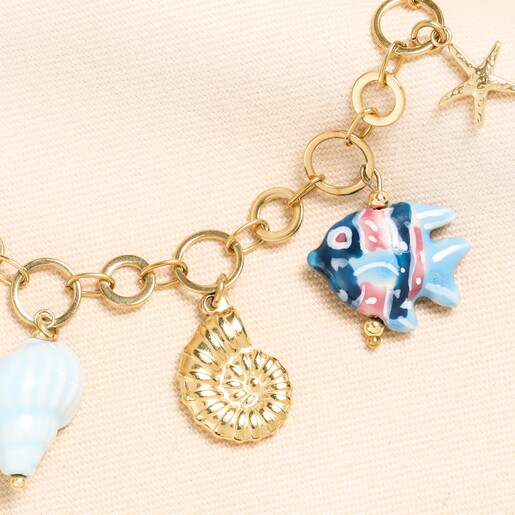 Close Up of Glass Fish Charm and Gold Metal Swirl Shell Charm