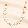 A Beaded Necklace With Gold and Pearl Accents Finished With Flower Shaped Beads