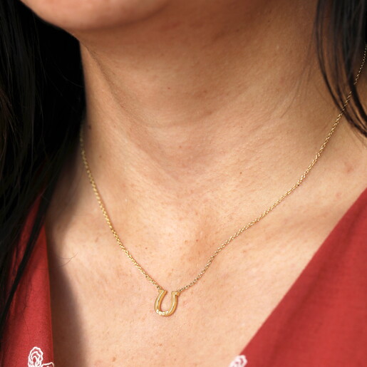 Close Up of Gold Horseshoe Charm Necklace with Clean Engraving on Model