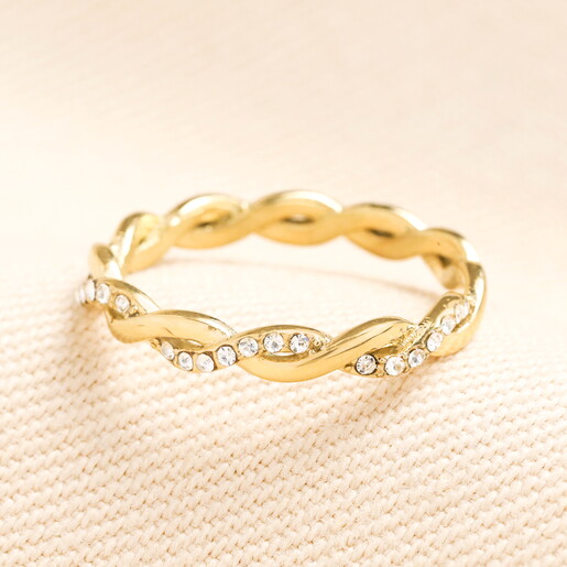 elegant ring in gold against pale pink background