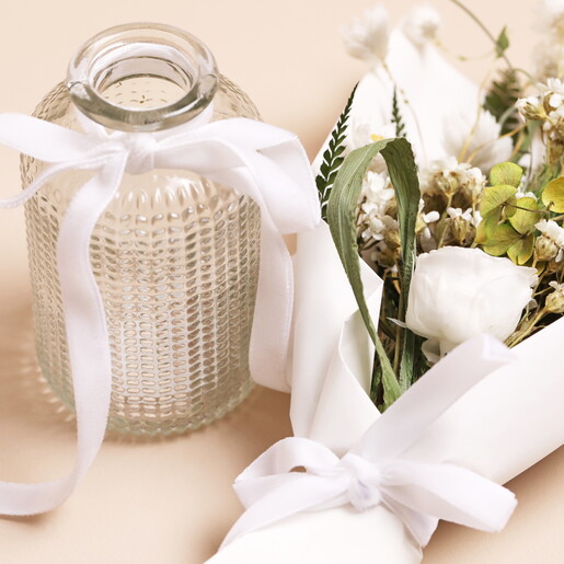 Close Up of Green and White Dried Flower Posy Out of Glass Vase