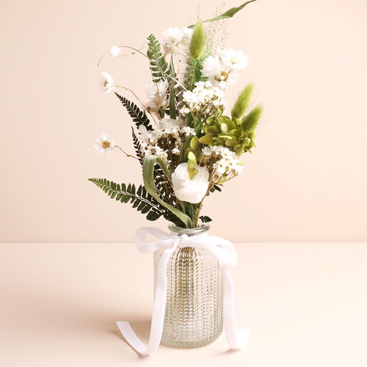 A Pretty Dried Flower Posy of Greens and Whites in a Glass Vase with a Ribbon Detail