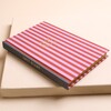 Angled view of pink striped 2027 diary showing grey spine