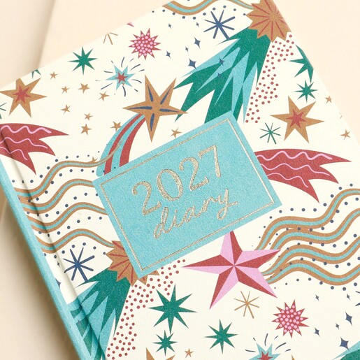 Close-up of the blue title plaque on the cream 2027 shooting star diary