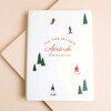 White faux leather notebook with colourful skiers and ski resort illustration on the front
