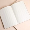 Open white vegan leather ski notebook displaying crisp lined paper pages inside