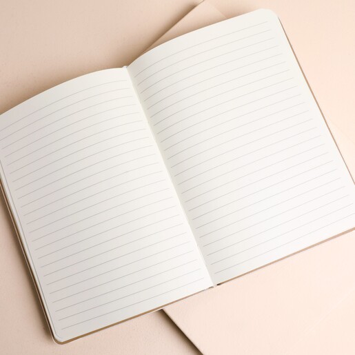 Open white vegan leather ski notebook displaying crisp lined paper pages inside