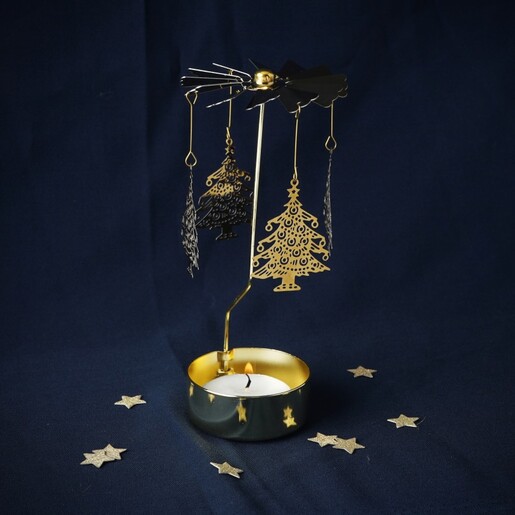 Lit gold Christmas tree tealight spinner candle holder on dark background