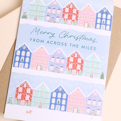 Close-up of the illustrated across the miles Christmas card with festive townhouses