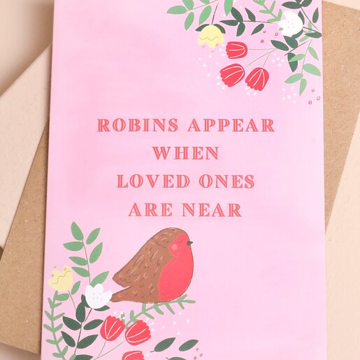 Close up of pink greetings card reading robins appear when loved ones are near