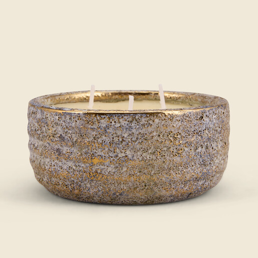 Side view of rustic textured ceramic candle pot with gold metallic rim.