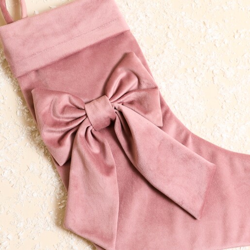Close-up of the statement oversized bow on the pink velvet stocking
