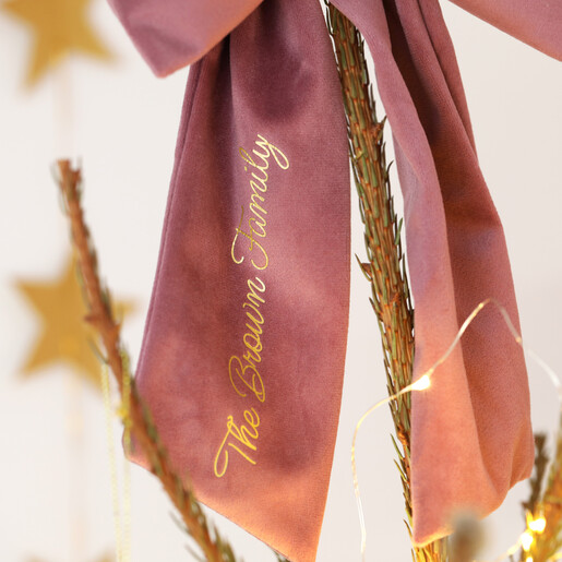 Close-up of gold script personalisation along the tail of the pink velvet bow