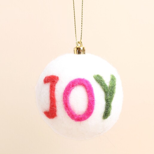 Close-up of white felt bauble featuring colourful red, pink and green JOY lettering.