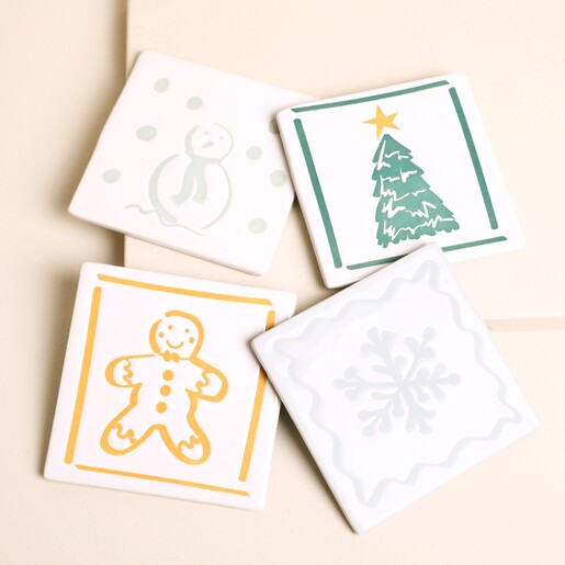 Set of four square white ceramic Christmas coasters with festive illustrations