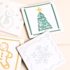 Close-up of four festive ceramic coasters with holiday designs