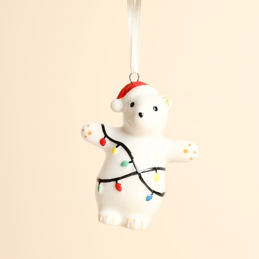 Close-up of ceramic polar bear decoration wrapped in painted Christmas fairy lights