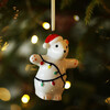 Ceramic Christmas polar bear hanging among warm lights on a Christmas tree