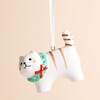 Close-up of the ceramic cat ornament showing painted facial features and red bow