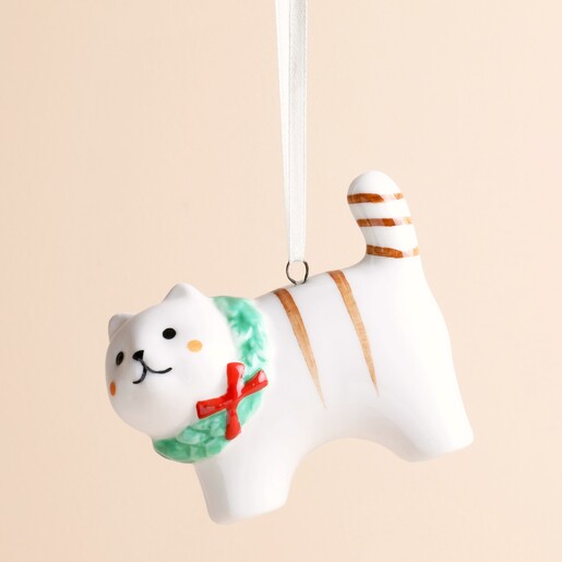 Close-up of the ceramic cat ornament showing painted facial features and red bow
