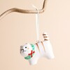 Ceramic cat hanging decoration with painted wreath hanging against a plain background