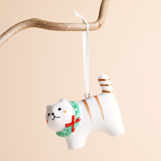 Ceramic cat hanging decoration with painted wreath hanging against a plain background