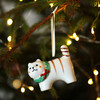Ceramic Christmas cat hanging decoration hanging on a lit Christmas tree branch