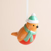 Close-up of glazed ceramic robin tree ornament with scarf and bobble hat