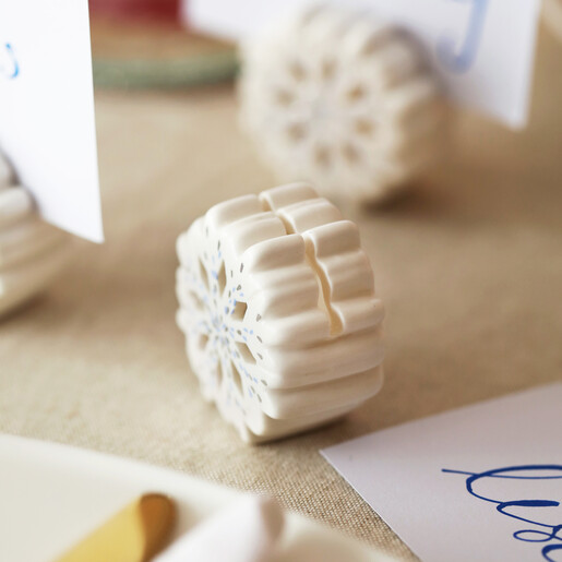 Close up of white ceramic snowflake place card holder showing blue dotted detailing
