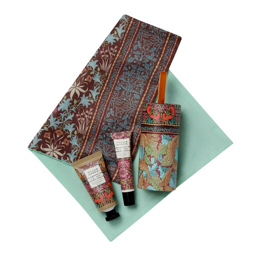 Unrolled floral fabric cracker wrap next to cylinder and beauty products