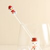 Close up of a clear glass drink stirrer with a snowman topper in a glass