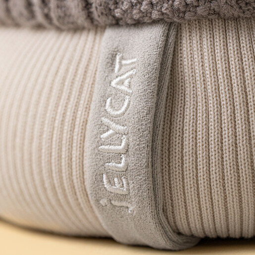 Detail of cream ribbed cuff and embroidered Jellycat tag on Pomilly