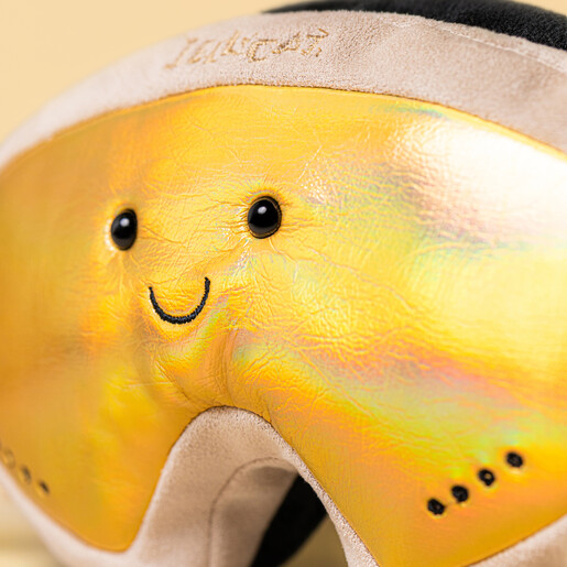 Close-up of shimmering golden visor with stitched smile and beaded eyes
