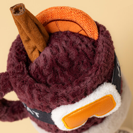 Close-up of the cinnamon stick, orange slice and goggles on the spiced drink soft toy