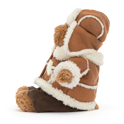 Side view of Jellycat Bartholomew Bear soft toy sitting in cosy winter clothing