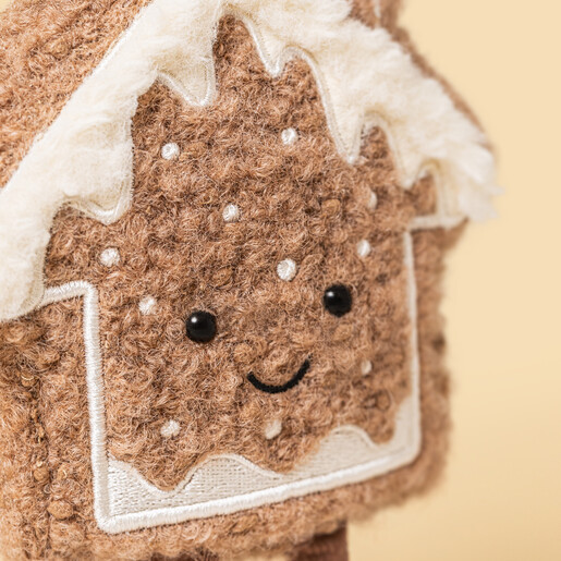 Close-up of the Jellycat Molasi Cookie plush face with embroidered icing and smile