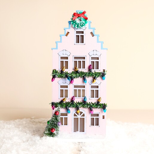 Front view of wooden lilac LED townhouse Christmas decoration with retro festive garlands
