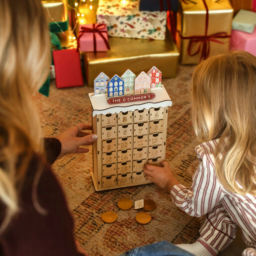Mother and child sitting beside the personalised wooden townhouse advent calendar