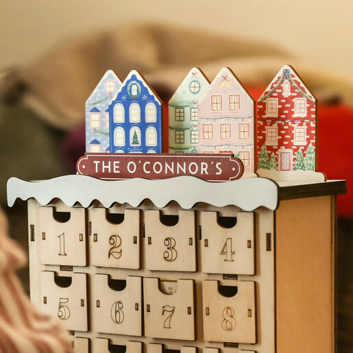 Child opening a drawer on a personalised wooden townhouse advent calendar